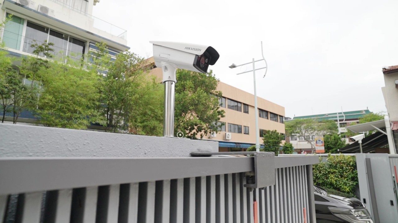 Câmera Hikvision no acesso veicular de condomínio, com portão e circulação de veículos