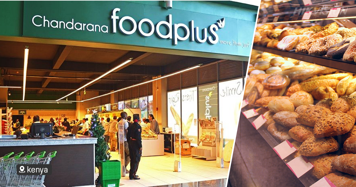Área de checkout e entrada de supermercado em funcionamento, com fluxo de clientes
